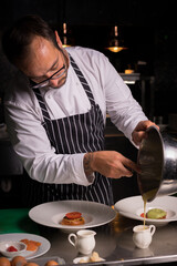 Chef cook preparing eggs  in his kitchen.Early meal with fried eggs served in pan. Breakfast Buffet Concept, Breakfast Timeю. Various brunch on the table