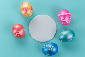 Minimal easter card. Five easter trendy color decorated eggs on light blue background. Round copy space for text.