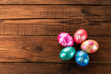 Five easter eggs trendy colored classic blue, green, orange, magenta and golden decorated on old wooden table. Copy Space.