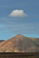 Fototapeta na wymiar A volcanic mountain with a single cloud on top. Lanzarote, Spain.