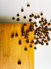 Coffee beans lie on wooden board and white table
