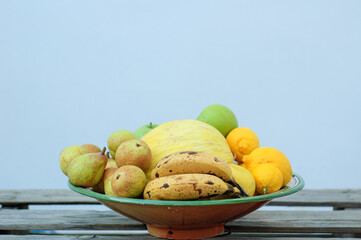 fruit center with melon apples lemons bananas pears on wooden table made with pallets