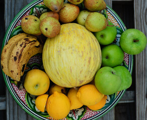 fruit center with melon apples lemons bananas pears on wooden table made with pallets