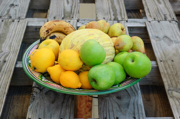 fruit center with melon apples lemons bananas pears on wooden table made with pallets