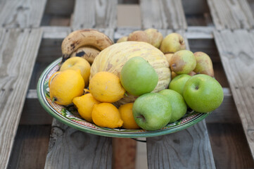 fruit center with melon apples lemons bananas pears on wooden table made with pallets