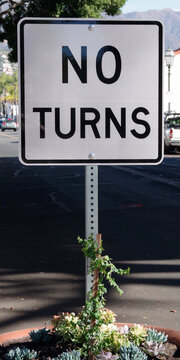 A temporary NO TURNS traffic sign in a large planter pot marking the city streets closure during the Covid pandemic 2020 and 2021