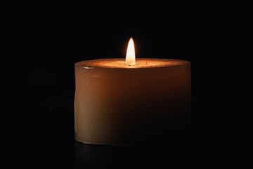 lighted candle on a black background