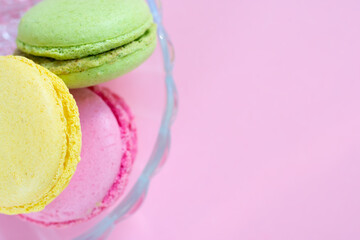 Traditional french dessert called macaroons. Colorful cookies made of almond flour with different cream fillings, top view on pink background