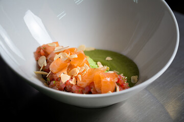 Chef cook preparing salad with salmon and avocado in his kitchen. Freezer food prepare in process vegetarian salad by chef hand in home kitchen. Dark black background with Text area for design menu 