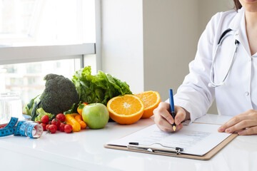 Female nutritionist doctor writing vegetable diet plan - obrazy, fototapety, plakaty