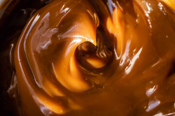closeup of spoon with dulce de leche on wooden base and dark background typical and traditional sweet from Argentina