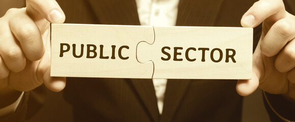 Businessman puts together wooden puzzles with the words Public sector. Enterprises, organizations and institutions owned and operated by state bodies. Business concept