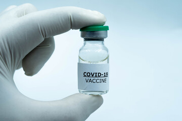 corona virus 2019 or covid-19 vaccine green cap vial in doctor hand