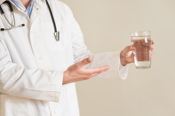 Image of male doctor showing on glass of water.