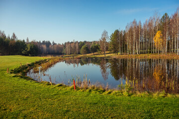 Autumn forest lake near golf field in Belarus Minsk region