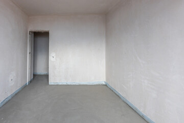 New empty room under construction. Plaster walls. New home. Concrete walls. Interior renovation.