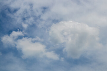 Tumbling pretty fluffy clouds with blue sky peaking through