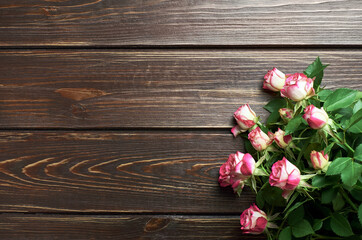 Fototapeta premium Fresh roses flowers bouquet on dark wooden background