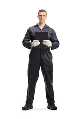 Fototapeta premium Full length portrait of a mechanic in a uniform standing and holding a document with a clipboard