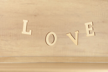 Flying in the form of word love on a wooden background. Happy Valentines Day