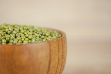 Mung bean, green moong dal in wooden bowl. Copy space. Wooden background.
