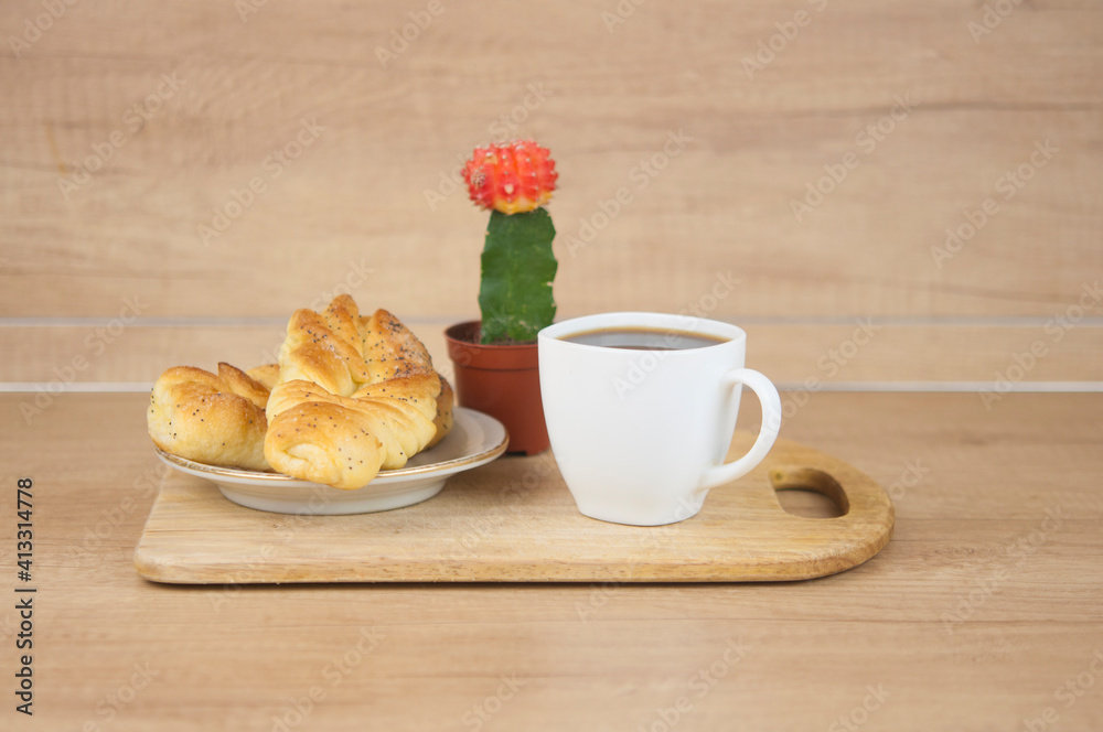 Canvas Prints Two bun with poppy seeds with coffee cup on wood table. Breakfast. Good Morning