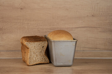 Homemade toasted whole wheat bread and metal form for bread