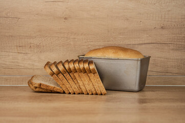 Homemade toasted whole wheat bread and metal form for bread