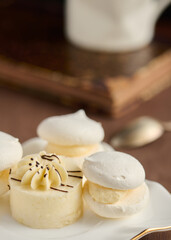 Souffle and meringue cakes on white saucer close-up