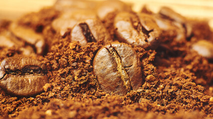 Macro roasted coffee beans scattered on ground coffee 