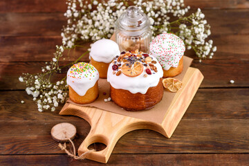 Festive cakes with white glaze, nuts and raisins with Easter eggs on the festive table