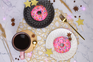 Obraz na płótnie Canvas Pink donuts with cup of black coffee on the white marble background