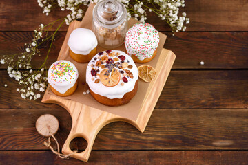 Festive cakes with white glaze, nuts and raisins with Easter eggs on the festive table