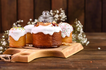 Festive cakes with white glaze, nuts and raisins with Easter eggs on the festive table