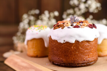 Festive cakes with white glaze, nuts and raisins with Easter eggs on the festive table