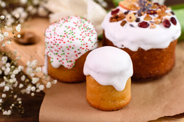 Festive cakes with white glaze, nuts and raisins with Easter eggs on the festive table