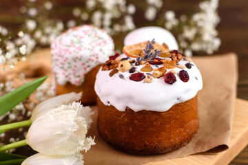 Festive cakes with white glaze, nuts and raisins with Easter eggs on the festive table