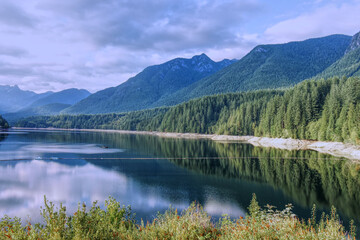 Fototapeta na wymiar A scenic View of Cleveland Dam reservoir surrounded by mountains at sunset, North Vancouver, Canada