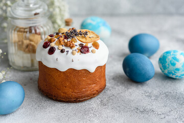 Festive cakes with white glaze, nuts and raisins with Easter eggs on the festive table