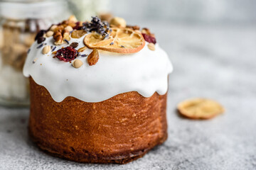 Festive cakes with white glaze, nuts and raisins with Easter eggs on the festive table
