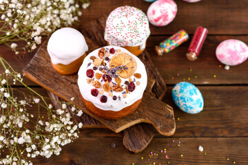 Festive cakes with white glaze, nuts and raisins with Easter eggs on the festive table