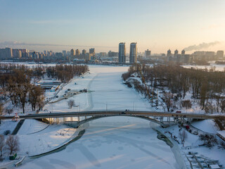 Obraz premium Bridge over a frozen river in Kiev. Aerial drone view. Winter sunny frosty morning.