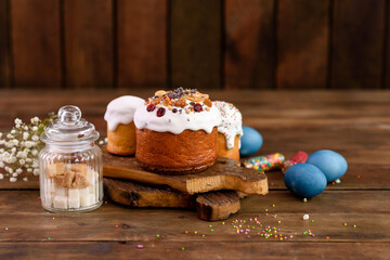 Festive cakes with white glaze, nuts and raisins with Easter eggs on the festive table