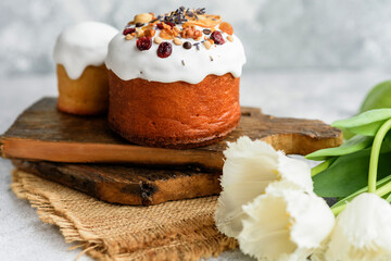 Festive cakes with white glaze, nuts and raisins with Easter eggs on the festive table