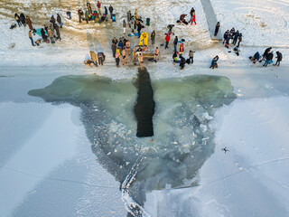 Aerial drone view. Epiphany swimming in an ice-hole in the river. Sunny frosty winter morning.