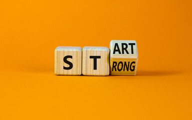 Start strong symbol. Turned wooden cubes with words 'start strong'. Beautiful orange background, copy space. Business and start strong concept.