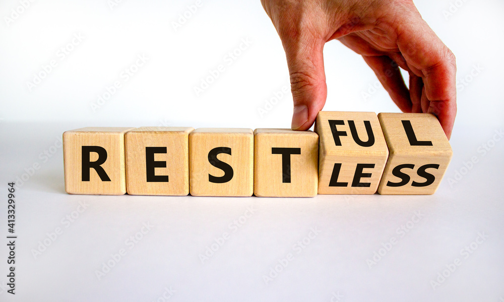 Fototapete restless or restful symbol. businessman turns wooden cubes, changes the word 'restless' to 'restful'