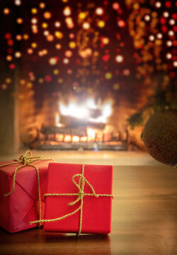 Xmas at home. Red gift boxes, blur burning fireplace background.