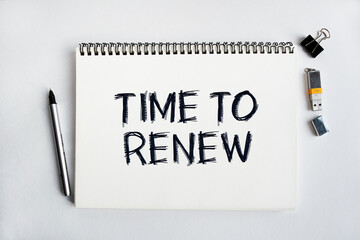 Notepad with the inscription TIME TO RENEW. Conceptual image, business accessories, calculator isolated on the desktop. Finance or business concept.
