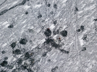 Aerial drone top view. Frosty pattern drawing on the river. Cloudy frosty winter morning.